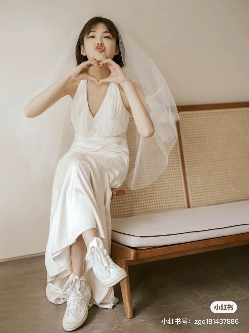 Người mẫu mặc váy lụa satin dài dự tiệc kết hợp giày thể thao