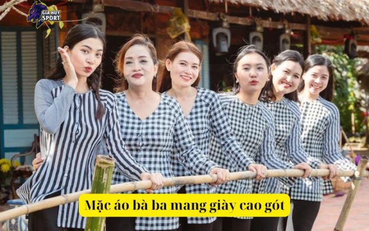 Người phụ nữ mặc áo bà ba màu xanh ngọc, đội nón lá và mang giày cao gót thanh lịch