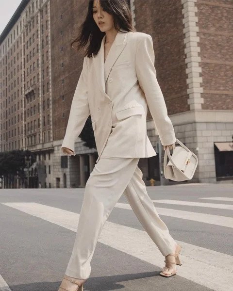Người phụ nữ mặc vest màu be thanh lịch với quần tây ống rộng, phối cùng giày cao gót mũi nhọn màu nude, tôn dáng và chuyên nghiệp