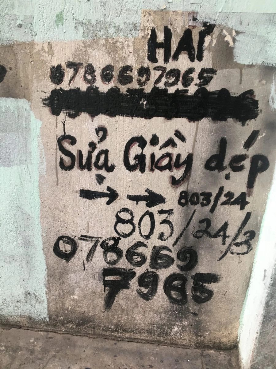 Người thợ đang dán đế giày thể thao tại tiệm sửa giày Hải ở Thủ Đức