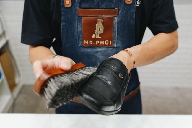 Quy trình vệ sinh và sửa chữa đế giày thể thao tại một trung tâm chăm sóc.