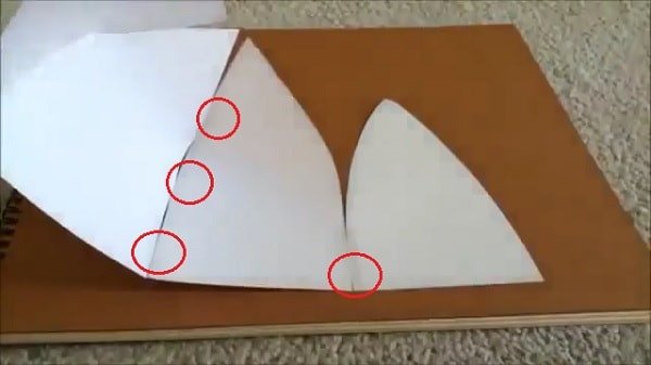 Sử dụng băng dính để kết nối hai mảnh giấy, tạo độ cong cho mũ