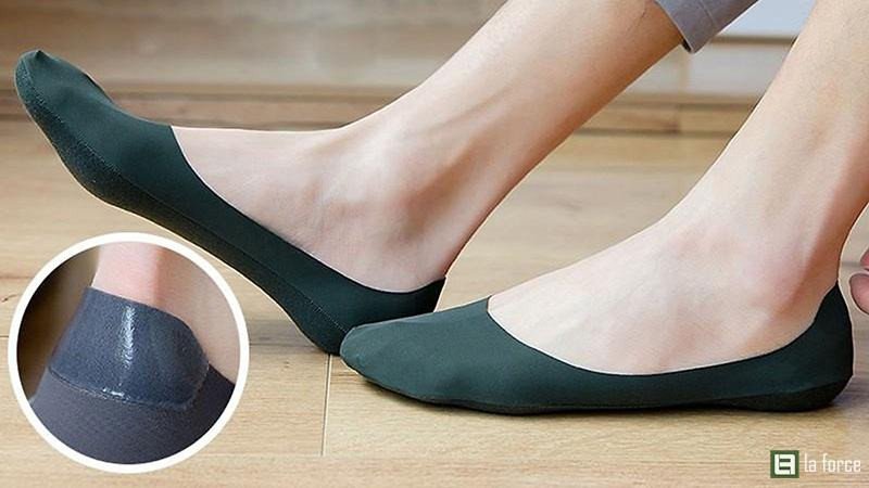 Tất lười màu đen được đặt bên cạnh một đôi giày loafer da