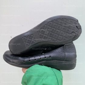 Thợ đang cẩn thận dán đế mới vào giày da Ecco nữ, đảm bảo sự chắc chắn.