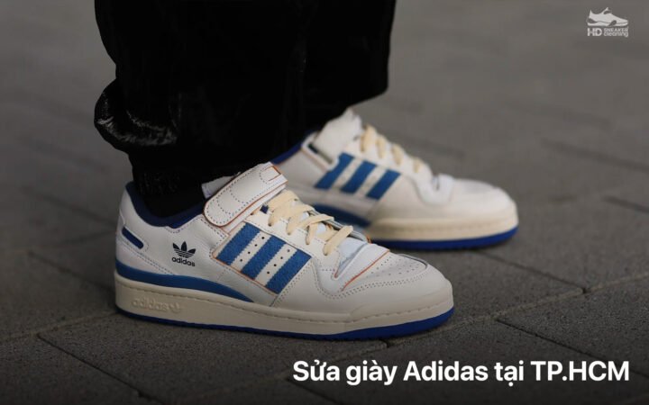Thợ thủ công đang kiểm tra chất lượng đế sau khi thay đế giày thể thao Adidas