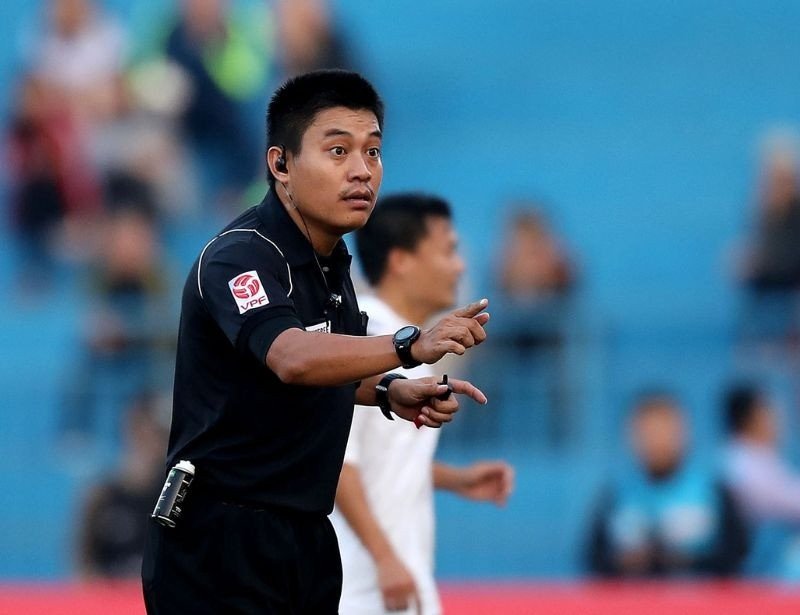 trọng tài đang đưa ra quyết định trên sân, nhấn mạnh vai trò của giày trọng tài bóng đá giúp duy trì sự tập trung