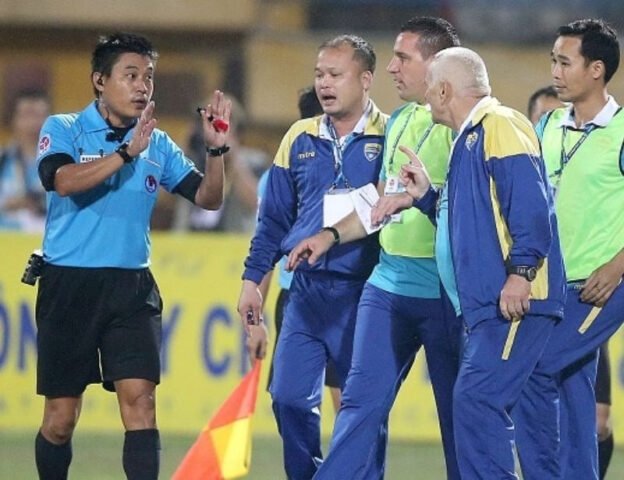 trọng tài đang thổi còi với trang phục chuyên nghiệp, thể hiện tầm quan trọng của giày trọng tài bóng đá