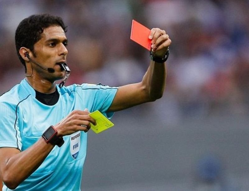 trọng tài rút thẻ vàng, minh họa vai trò quản lý của người cầm còi và tầm quan trọng của giày trọng tài bóng đá