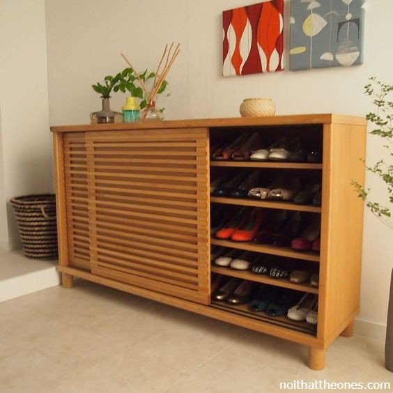 Tủ giày dép màu trắng đặt cạnh cửa ra vào