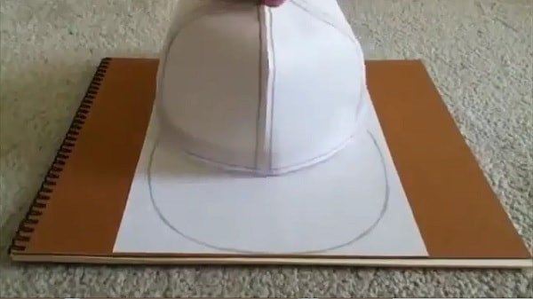 Vẽ và cắt hình lưỡi trai trên giấy để chuẩn bị cho mũ